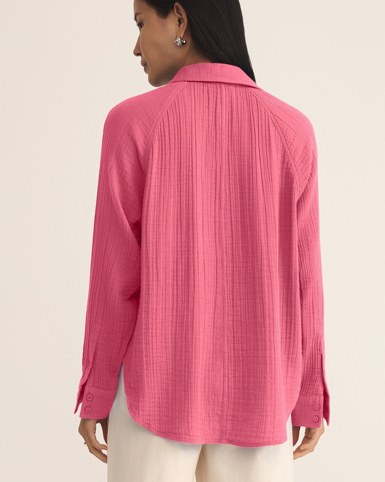 Woman wearing a pink textured shirt against a beige background
