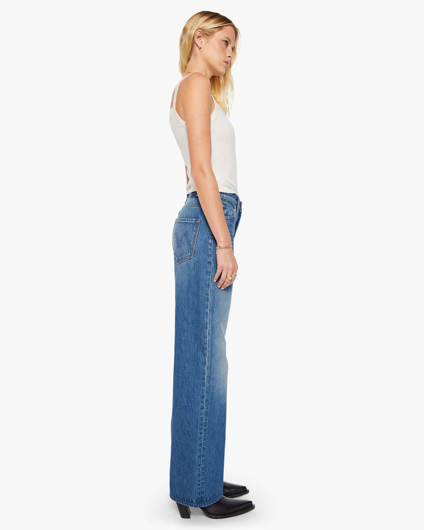 Woman wearing blue jeans and a white top on a white background