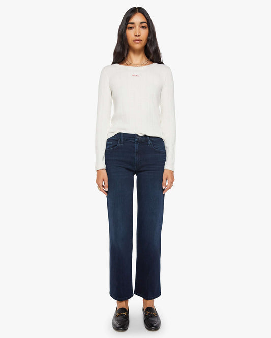 Woman wearing a white long-sleeve shirt and dark blue jeans on a white background
