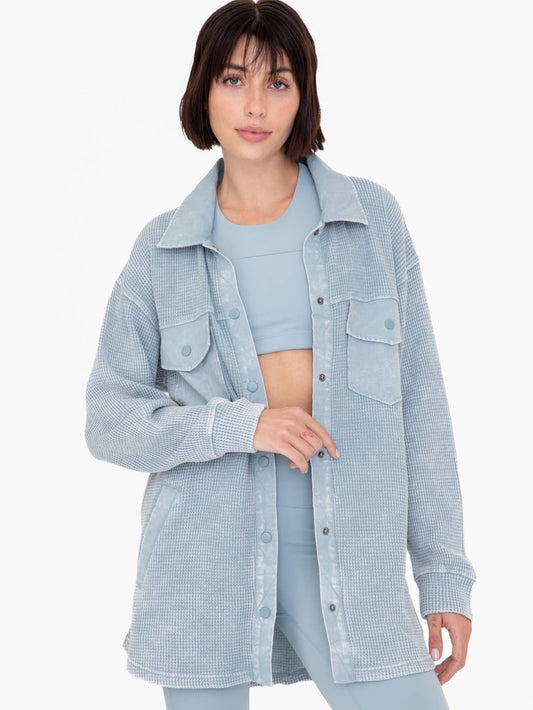 Model wearing Mono B Waffle Knit Mineral-washed button down jacket wearing Light blue sports bra and leggings on a white background