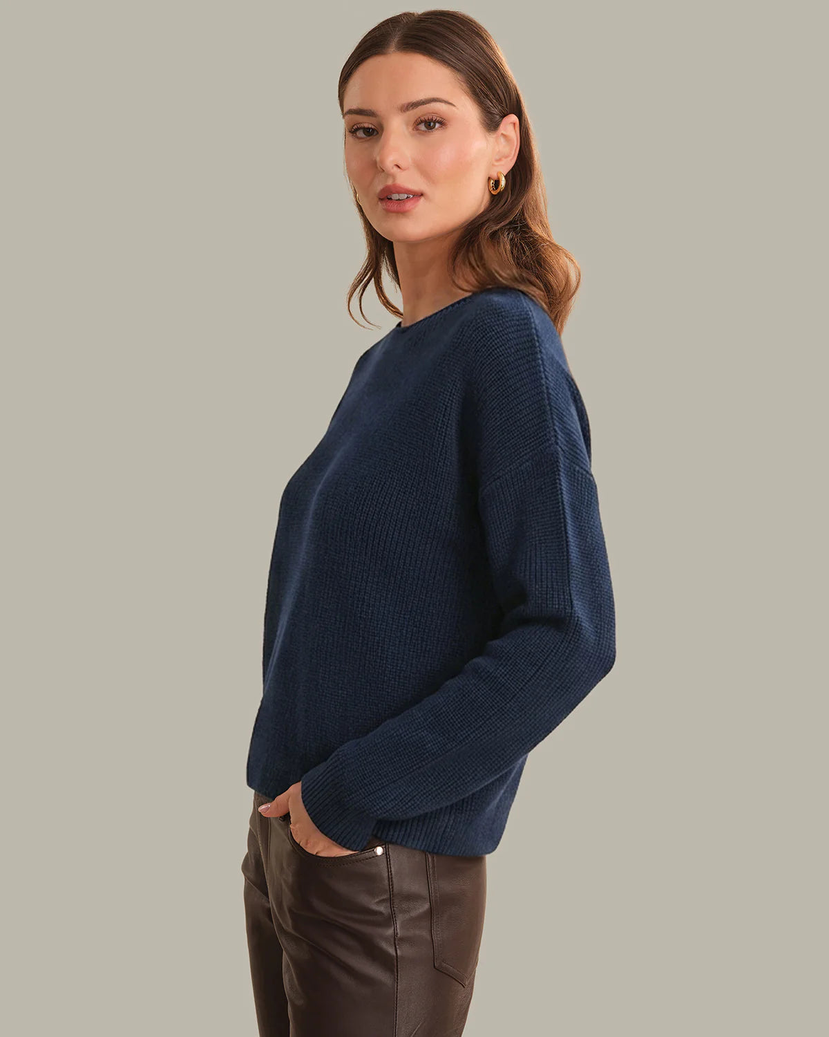 Woman wearing a navy blue sweater against a neutral background