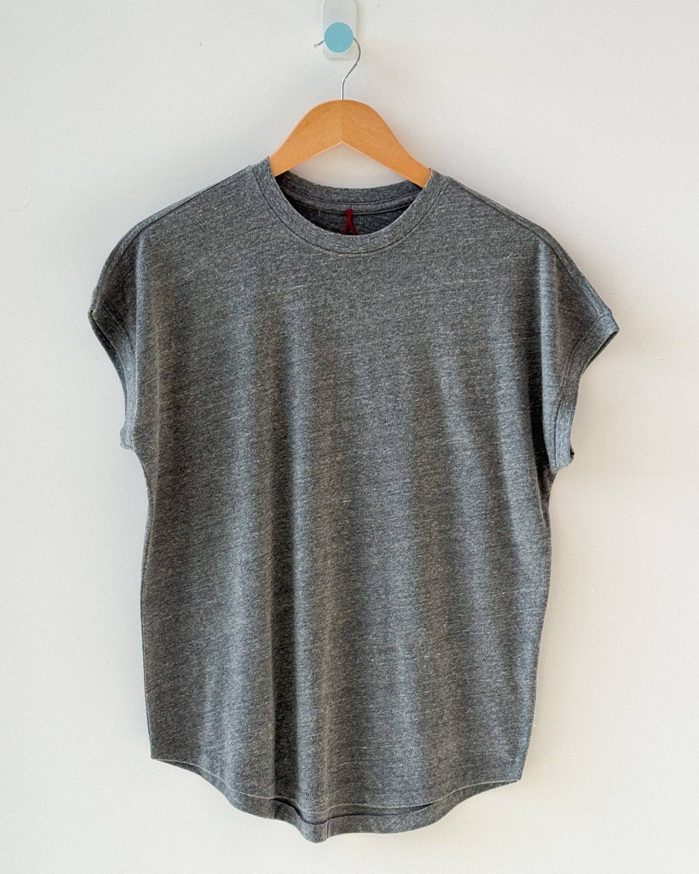 Gray sleeveless shirt on a wooden hanger against a white background