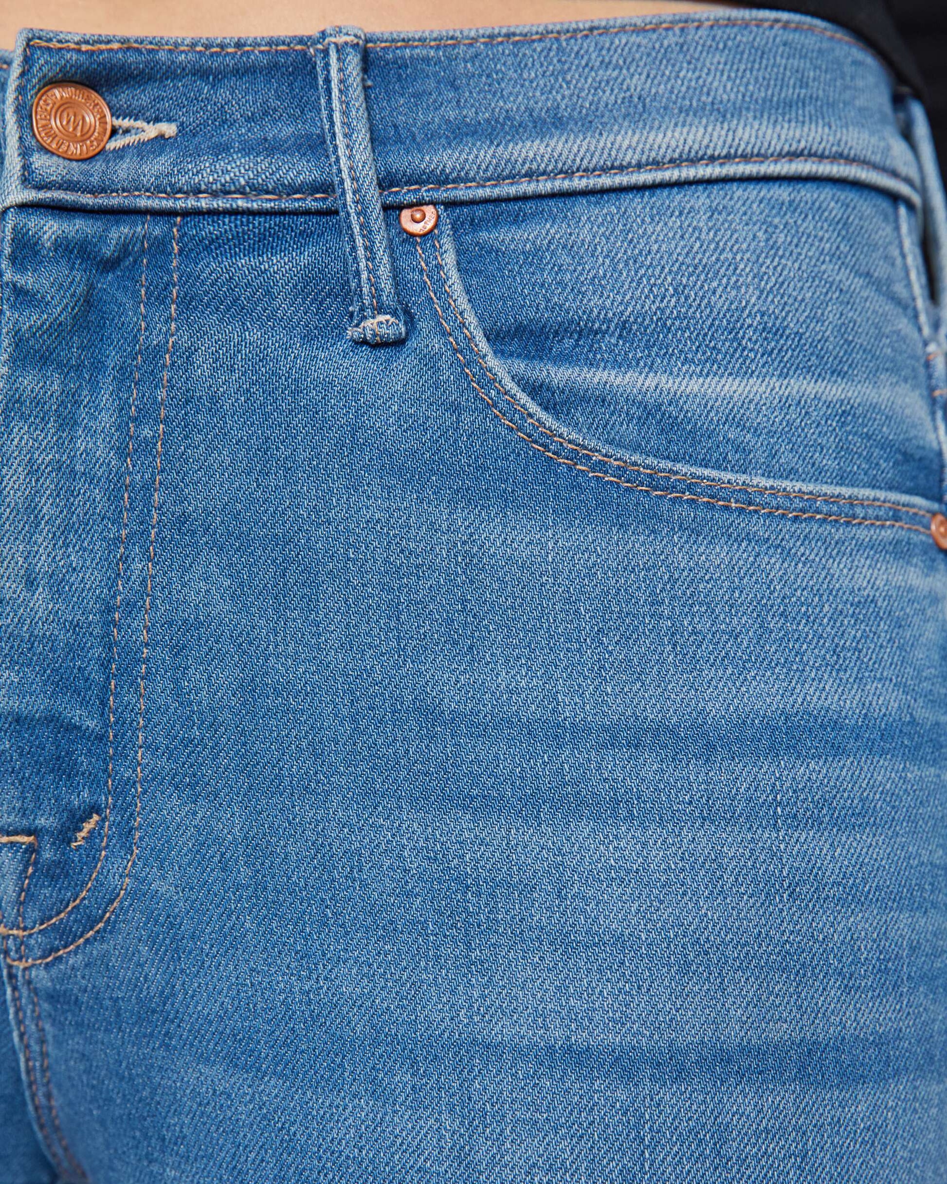 Close-up of blue jeans with a focus on the stitching and fabric texture.