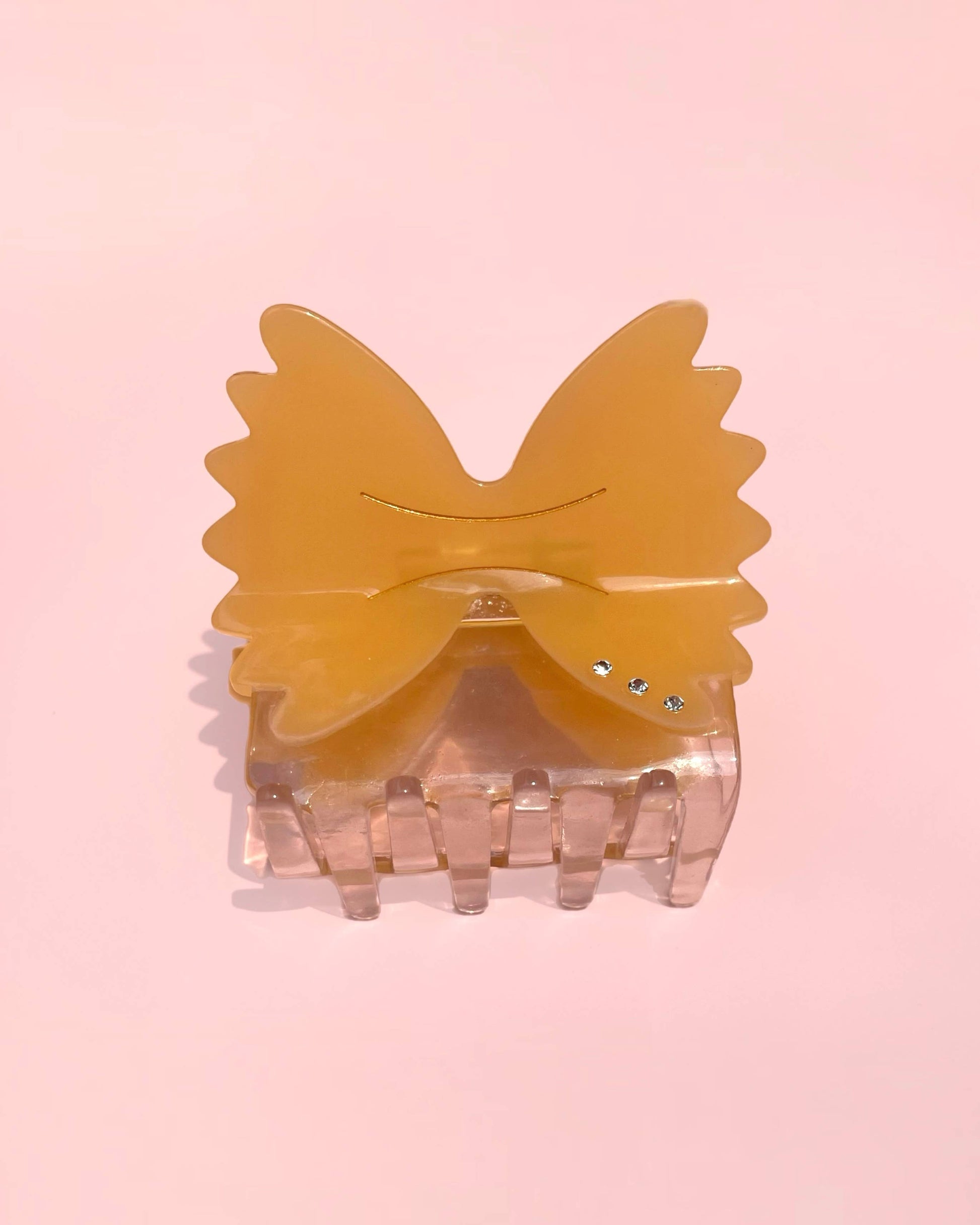 Yellow bow hair clip on a pink background