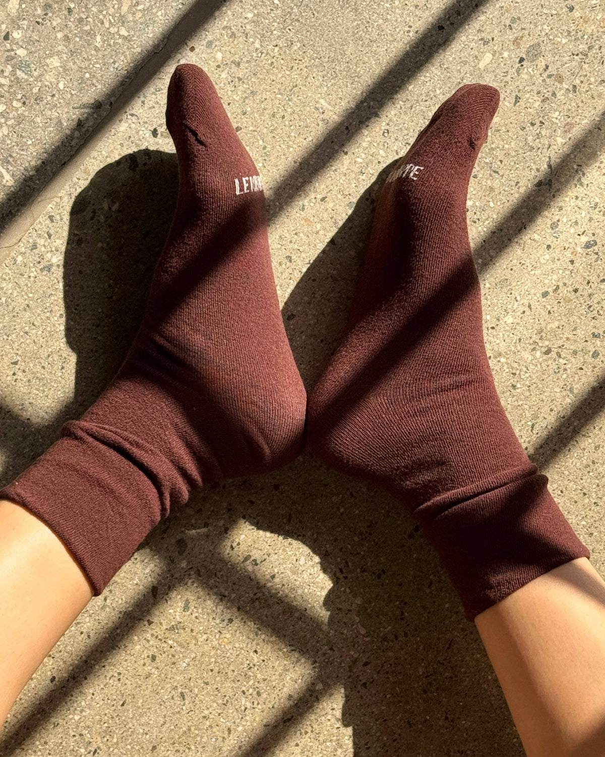 Brown socks with brand logo on a concrete surface