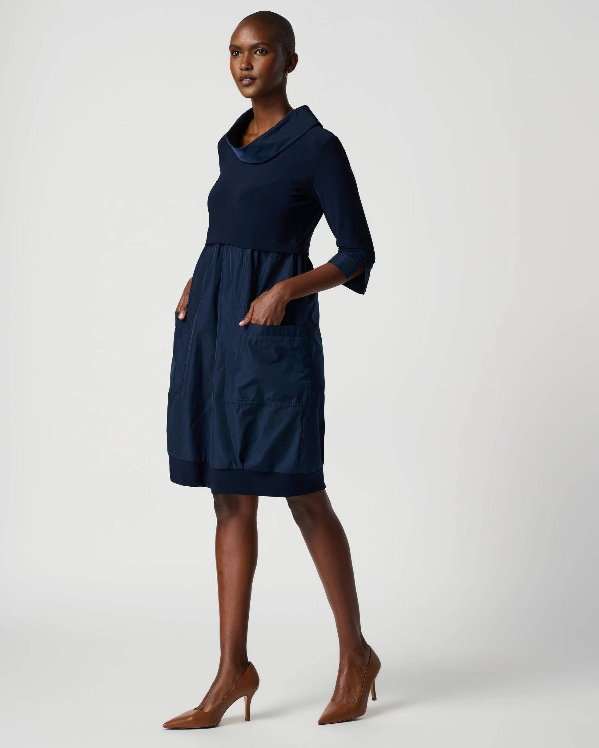 Woman wearing a navy blue dress on a white background