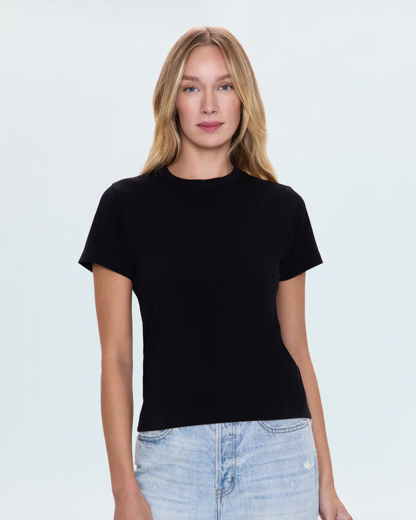 Woman wearing a black t-shirt and light blue jeans on a white background