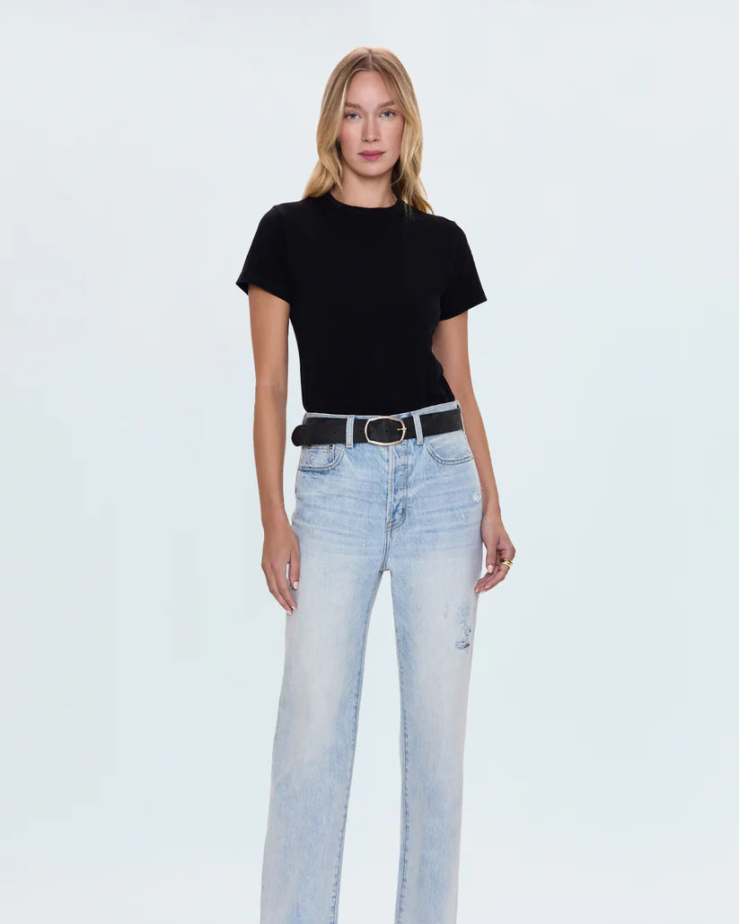 Woman wearing a black t-shirt and light blue jeans on a white background