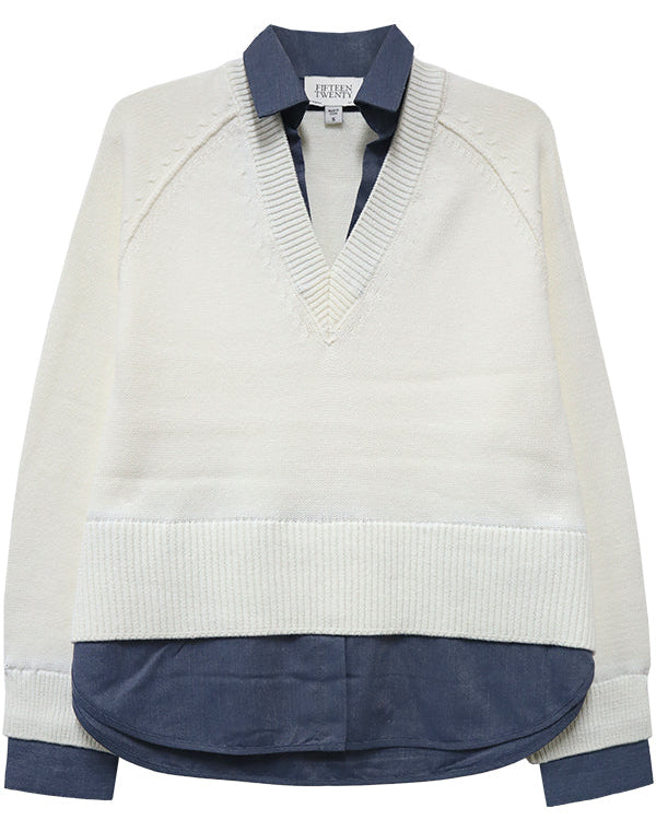 White sweater with navy accents on a white background