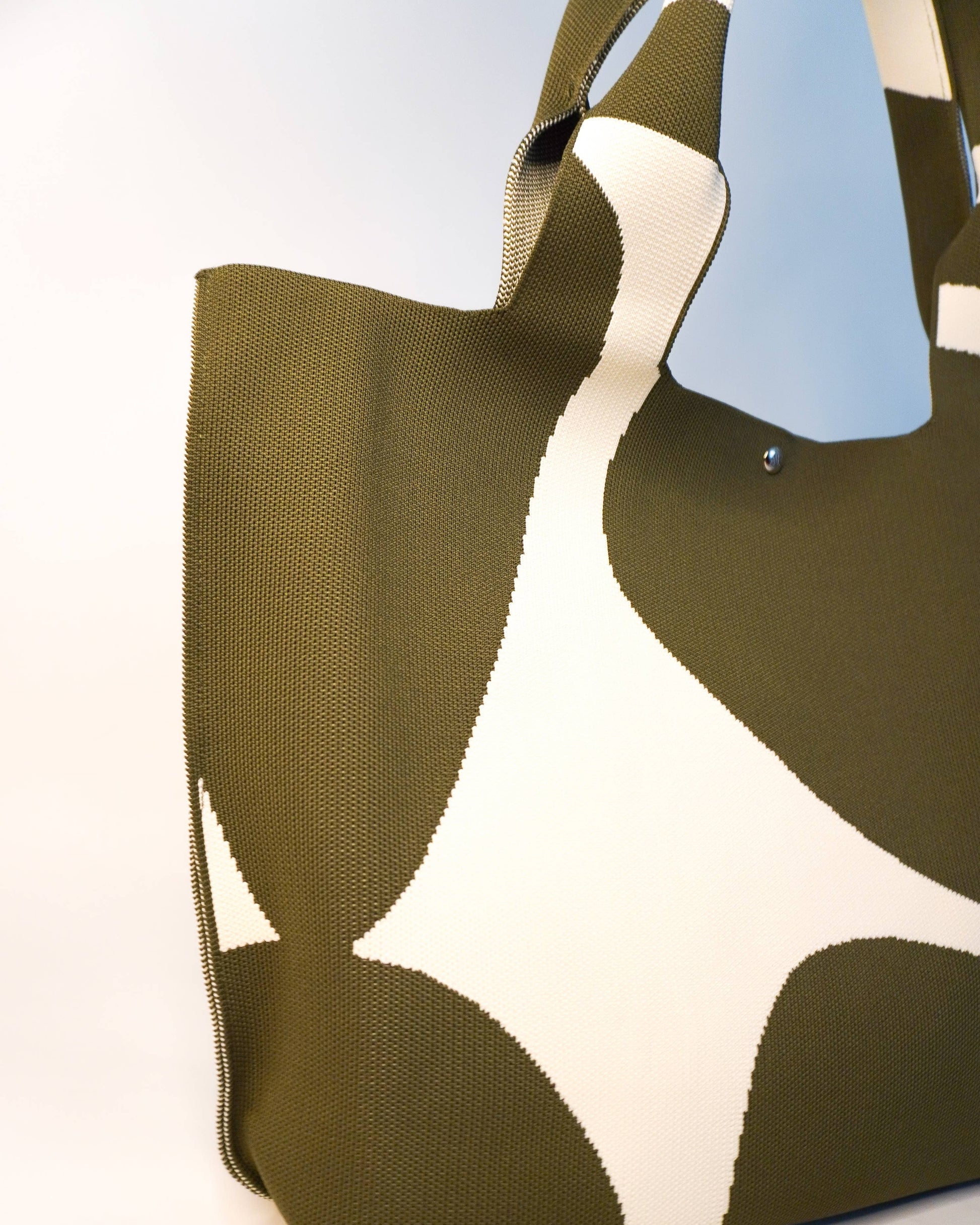 Green and white patterned bag on a white background