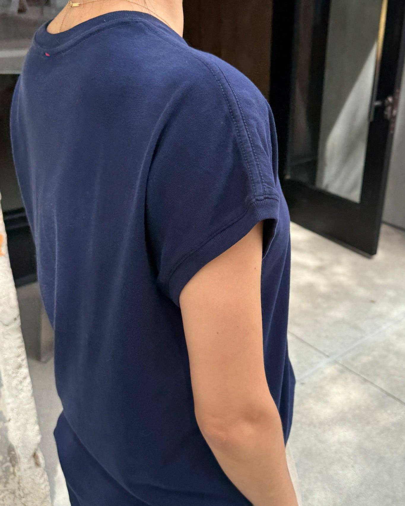 Person wearing a navy blue t-shirt in an indoor setting