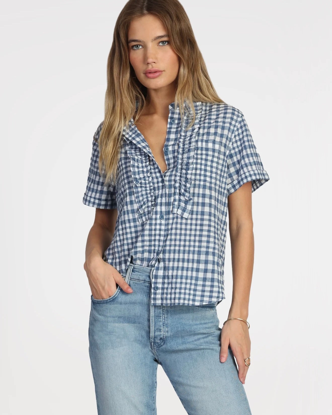 Model wearing Dylan Harper Ruffle Blouse in blue and white wearing jeans on a white background