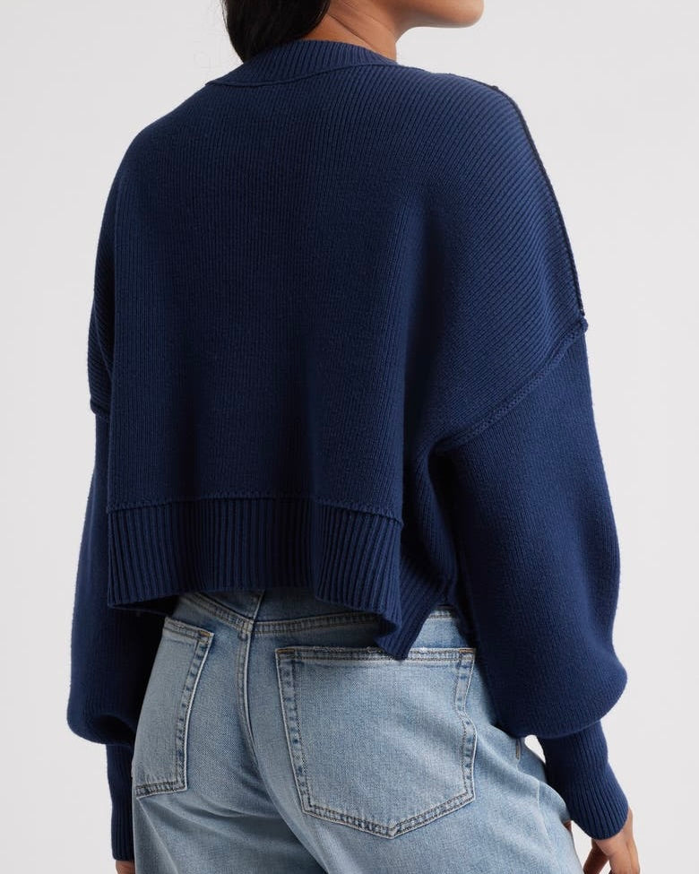 Back view of a model wearing the Free People Easy Street crop pullover sweater in navy in front of a white background.