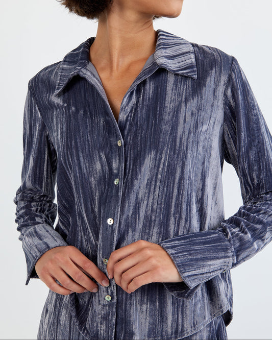 Woman wearing a blue patterned shirt against a white background