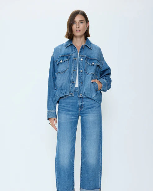 Woman wearing a blue denim jacket and jeans on a white background