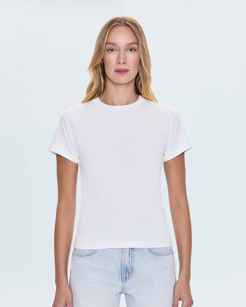 Woman wearing a plain white t-shirt and light blue jeans on a white background
