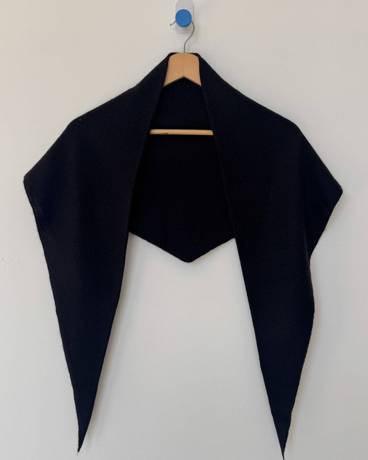 Black shrug on a hanger against a white background