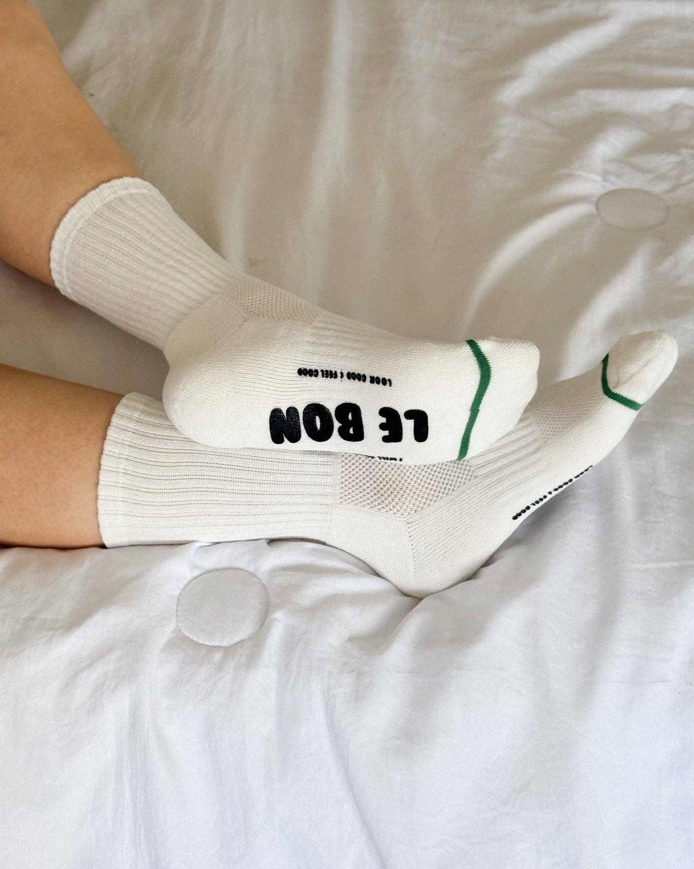 White socks with text on a white bed