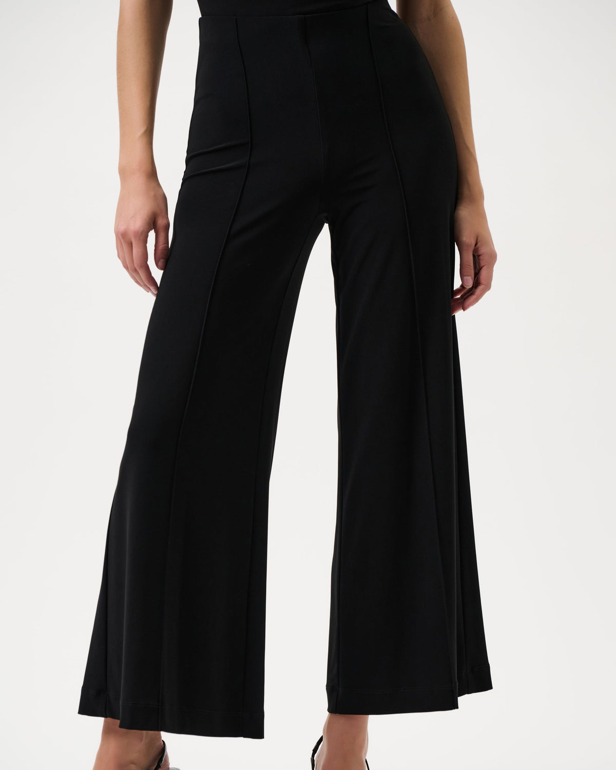 Black wide-leg pants worn by a person on a white background