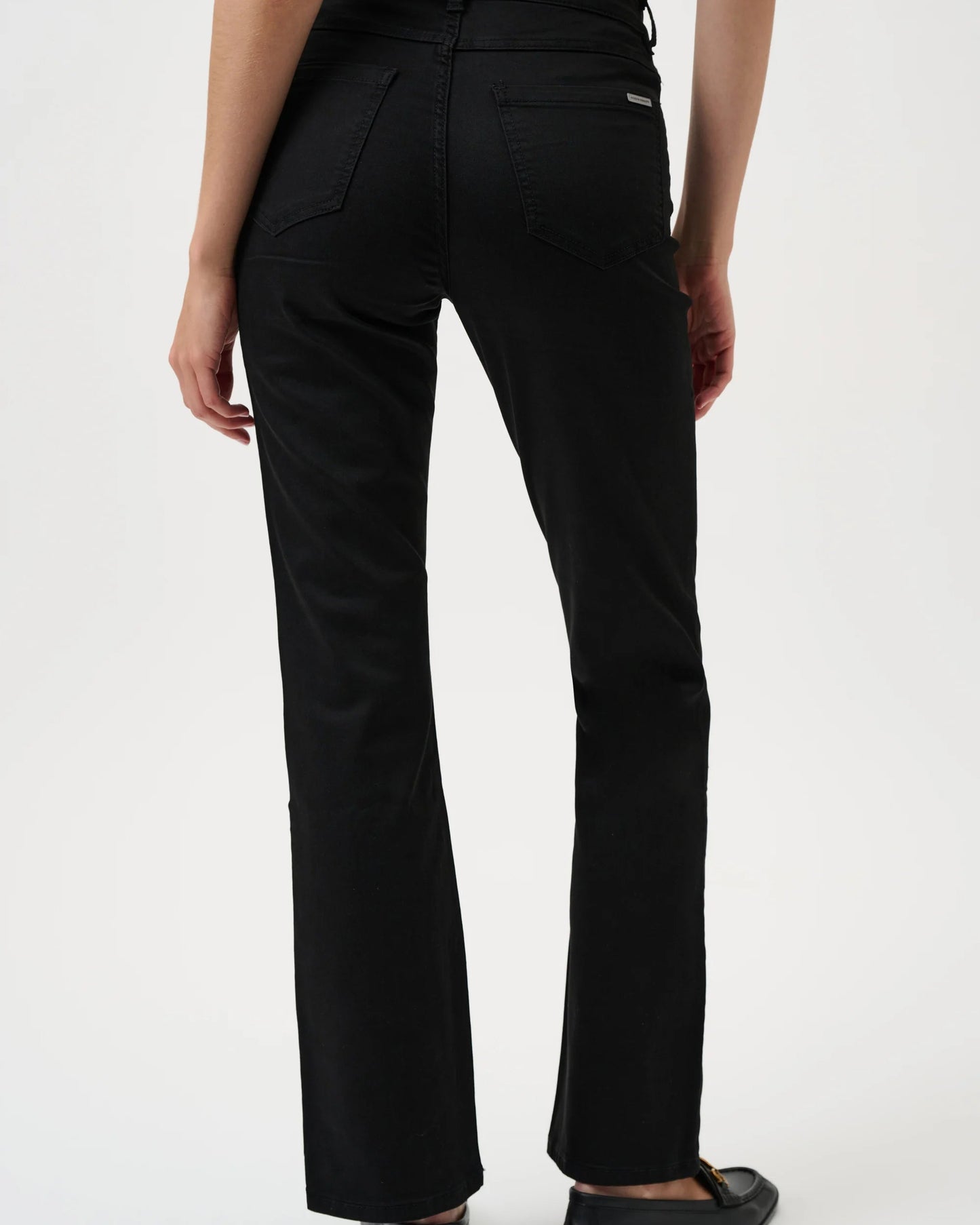 Black pants worn by a person on a white background