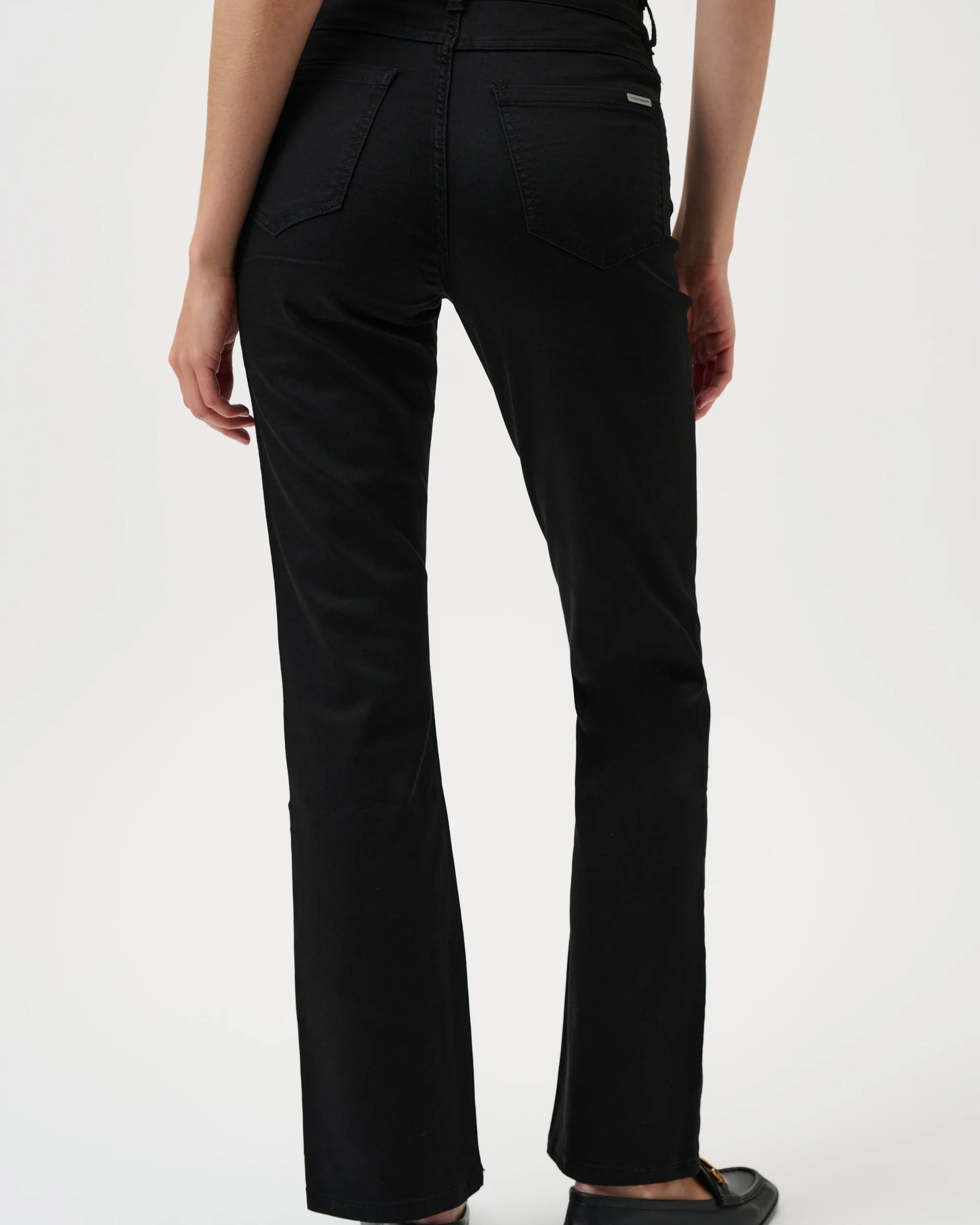Black pants worn by a person on a white background