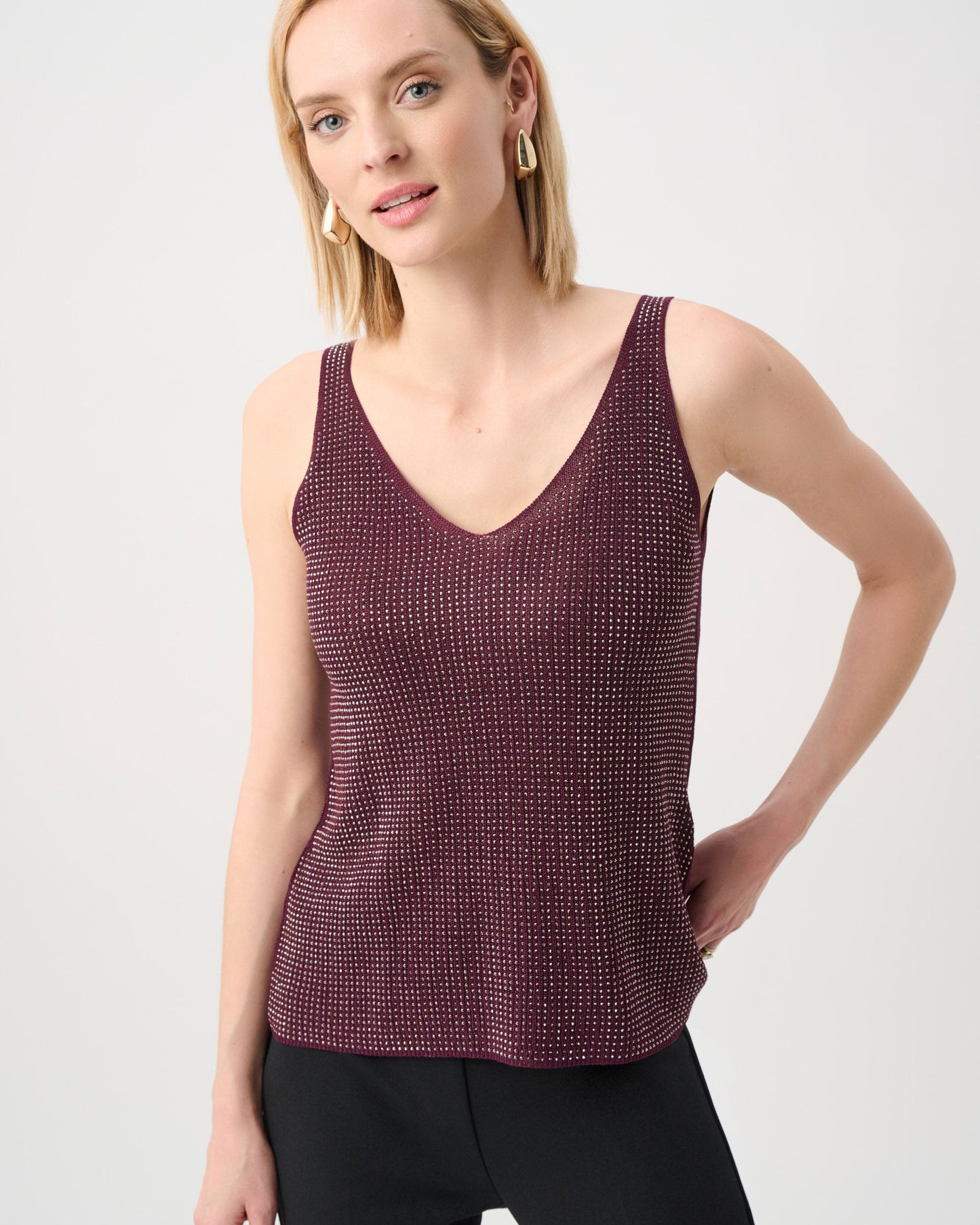 Woman wearing a maroon tank top against a white background
