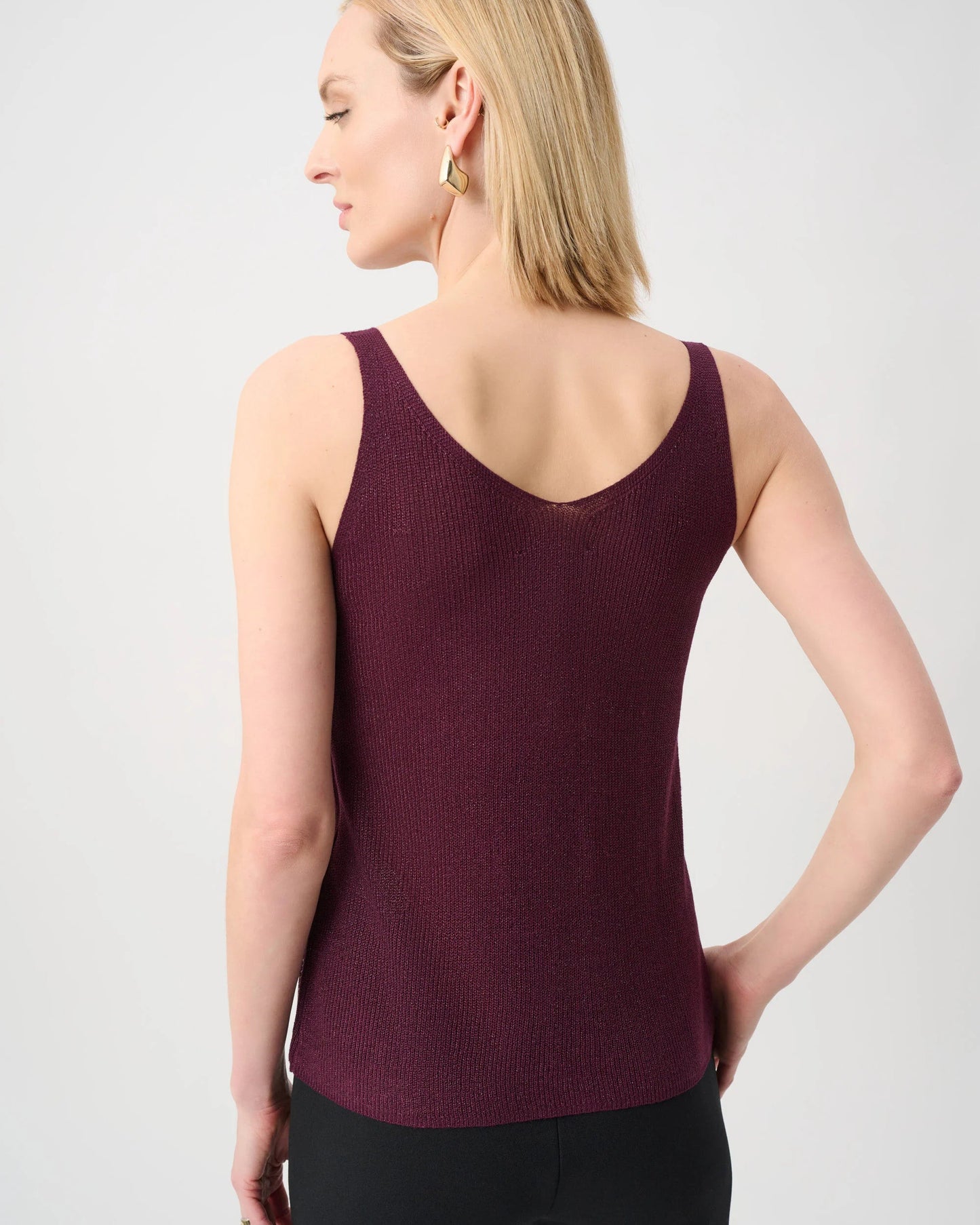 Woman wearing a burgundy tank top against a light gray background