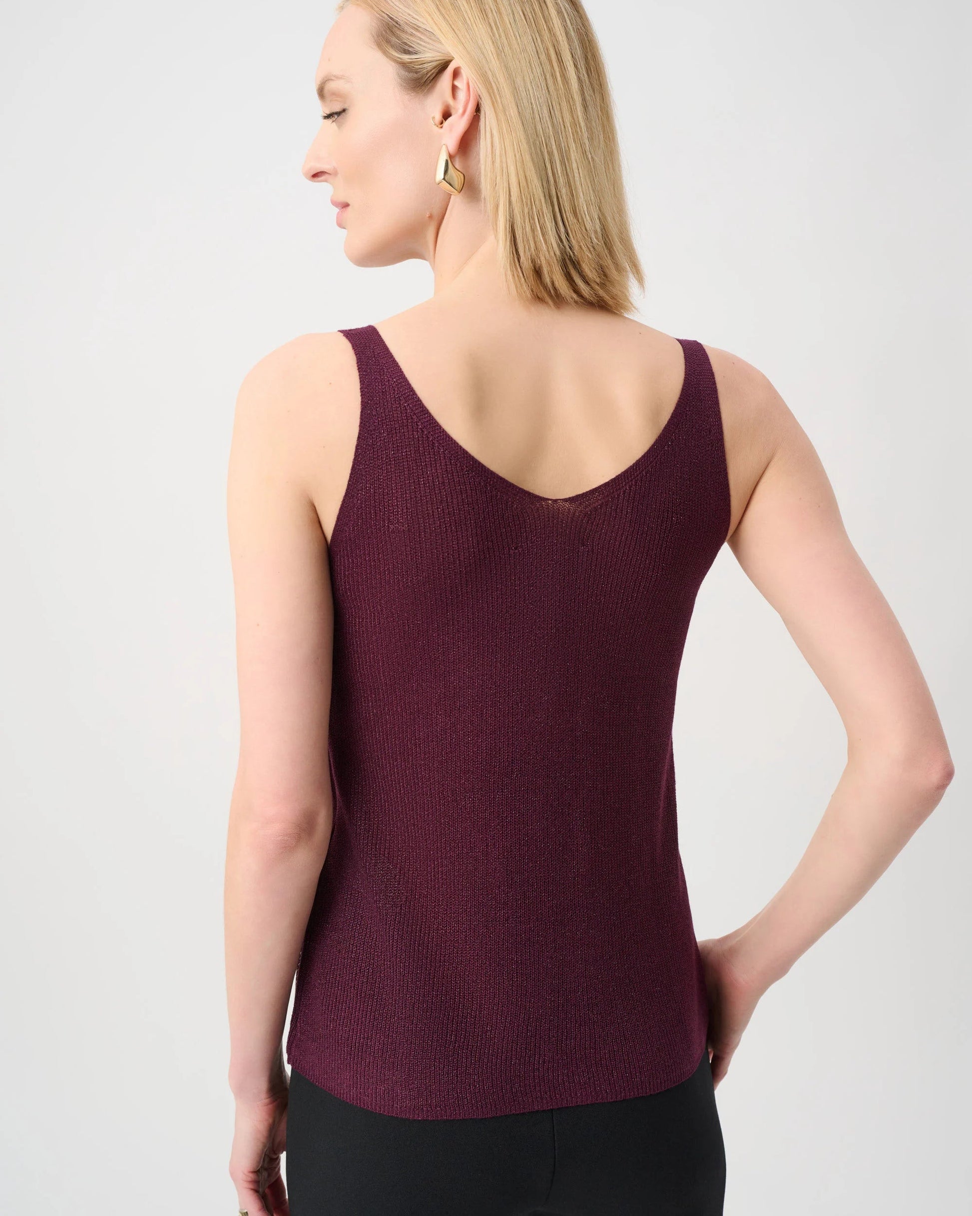 Woman wearing a burgundy tank top against a light gray background
