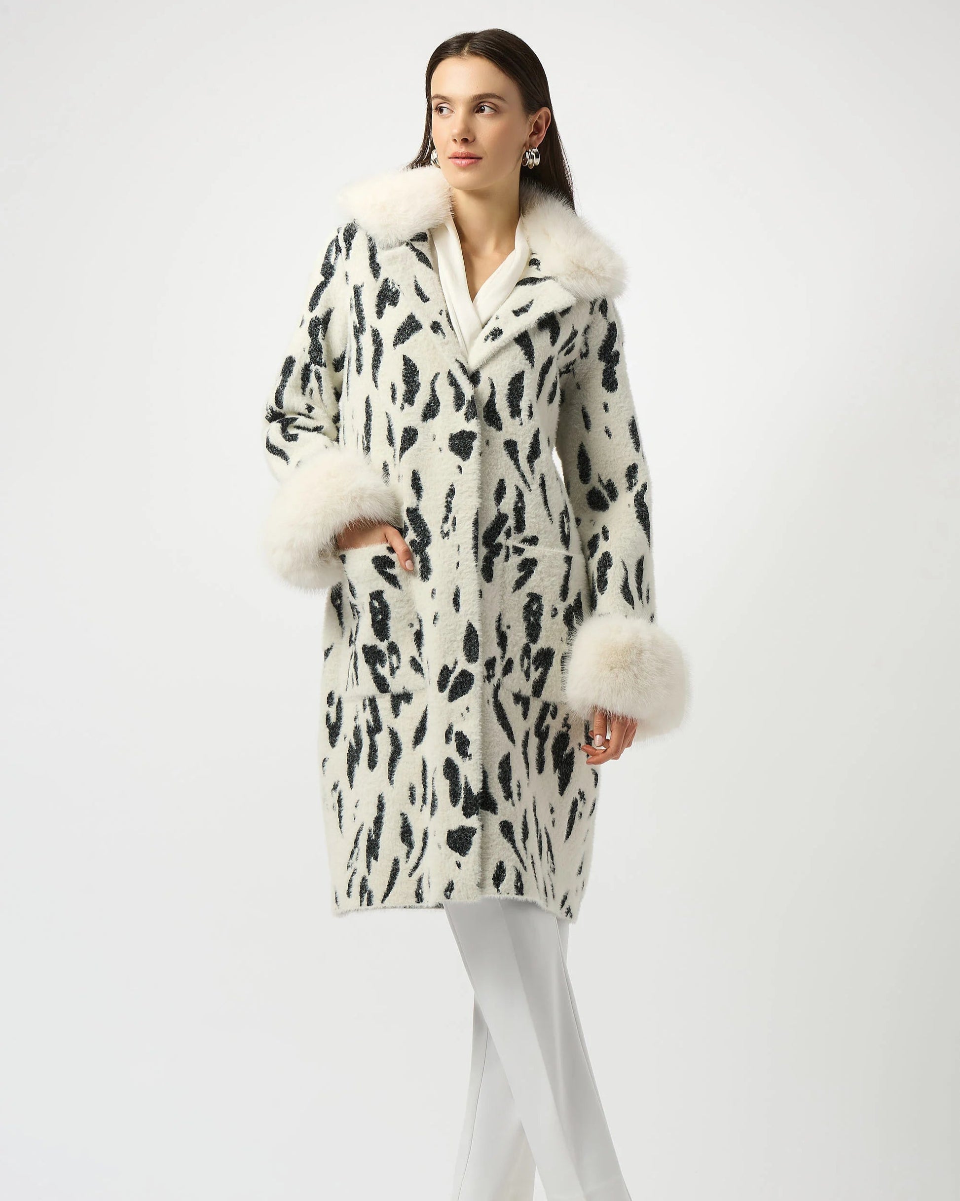 Woman wearing a patterned coat with fur trim on a white background