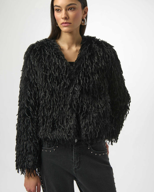 Woman wearing a black faux fur boxy jacket against a white background