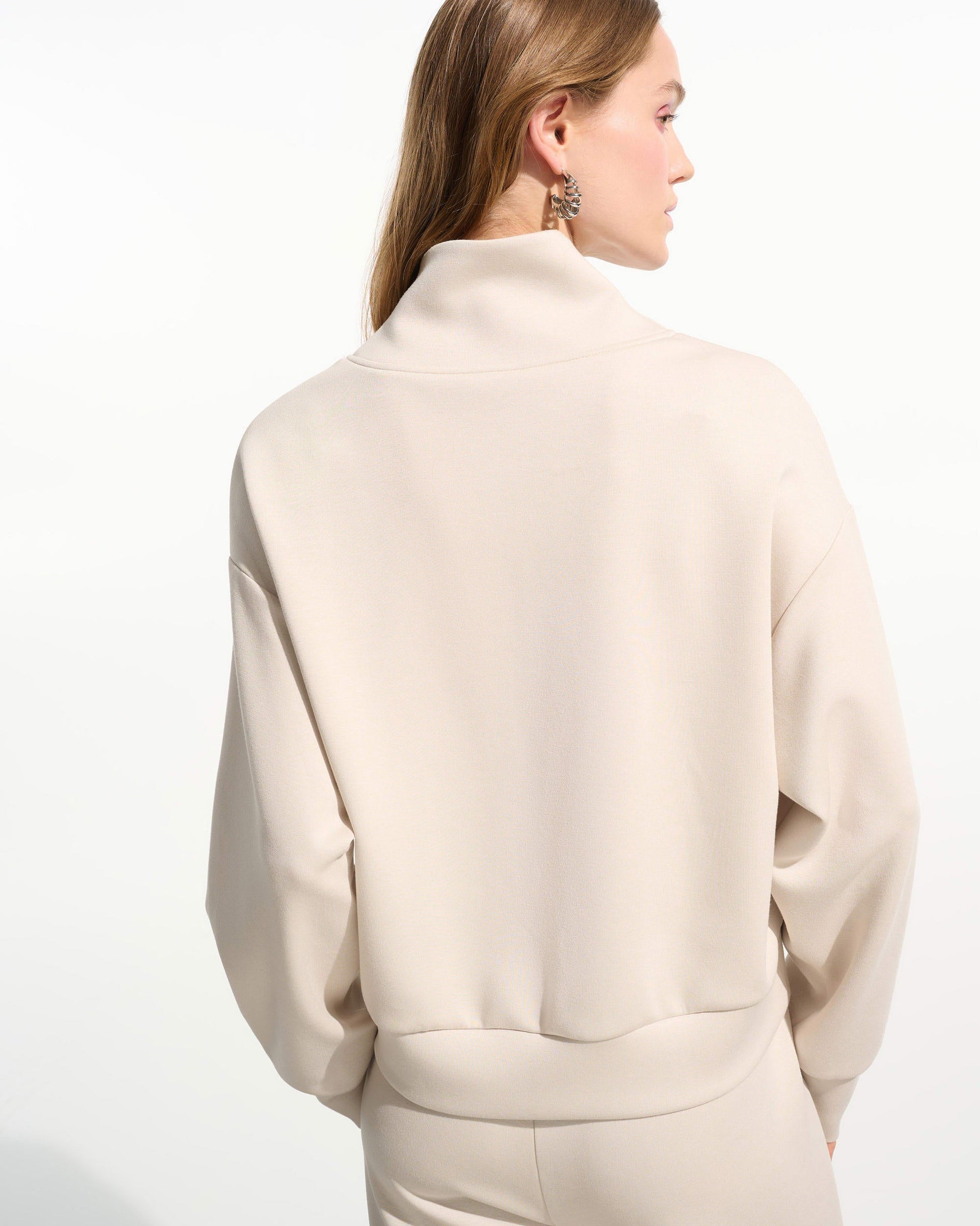 Woman wearing a beige outfit on a white background