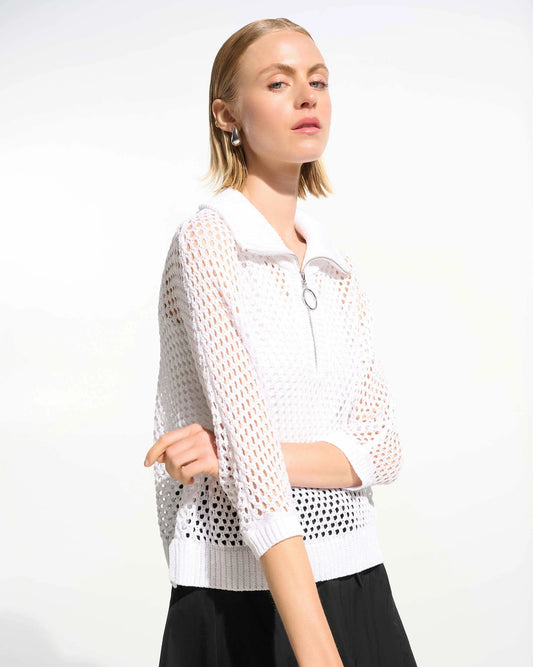 Woman wearing a white mesh top and black pants on a white background