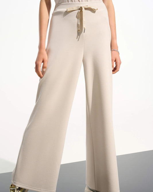 Beige drawstring pants on a model in front of a white background