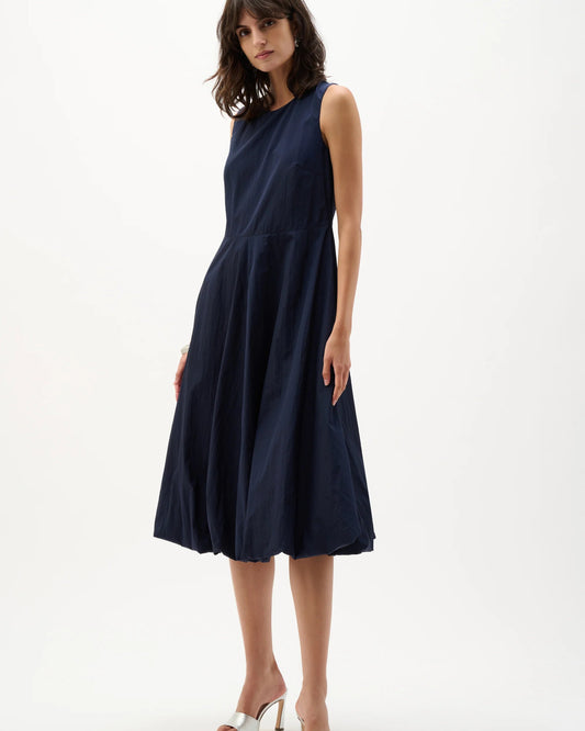 Woman wearing a navy sleeveless dress on a white background