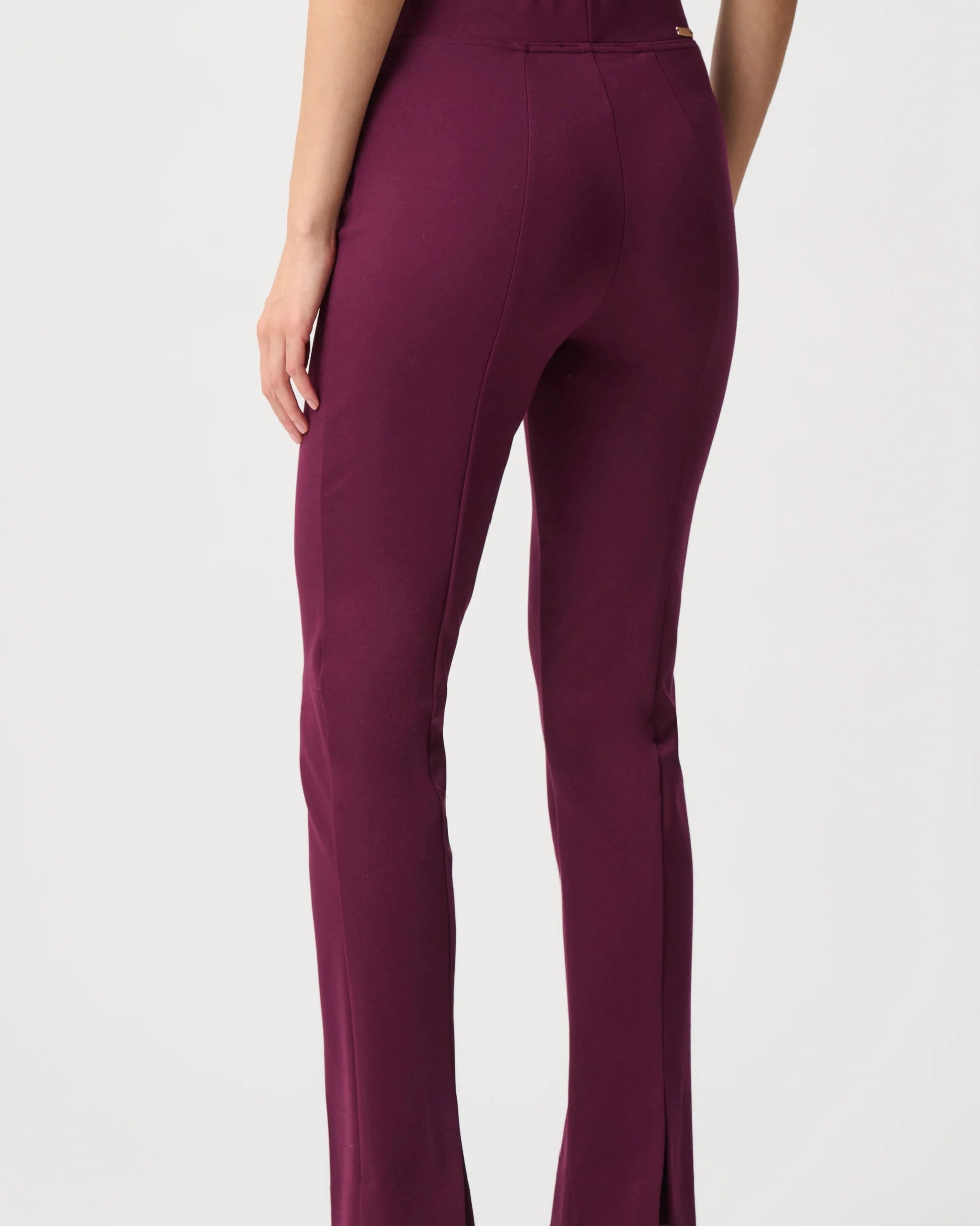 Purple pants worn by a person on a white background