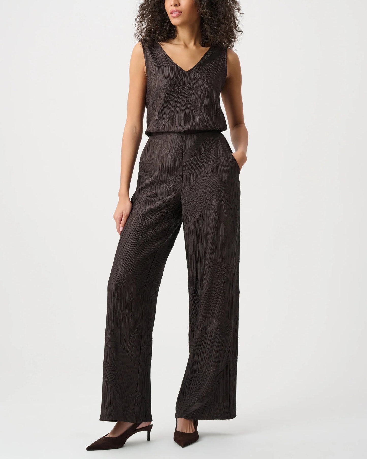 Woman wearing a brown jumpsuit on a white background
