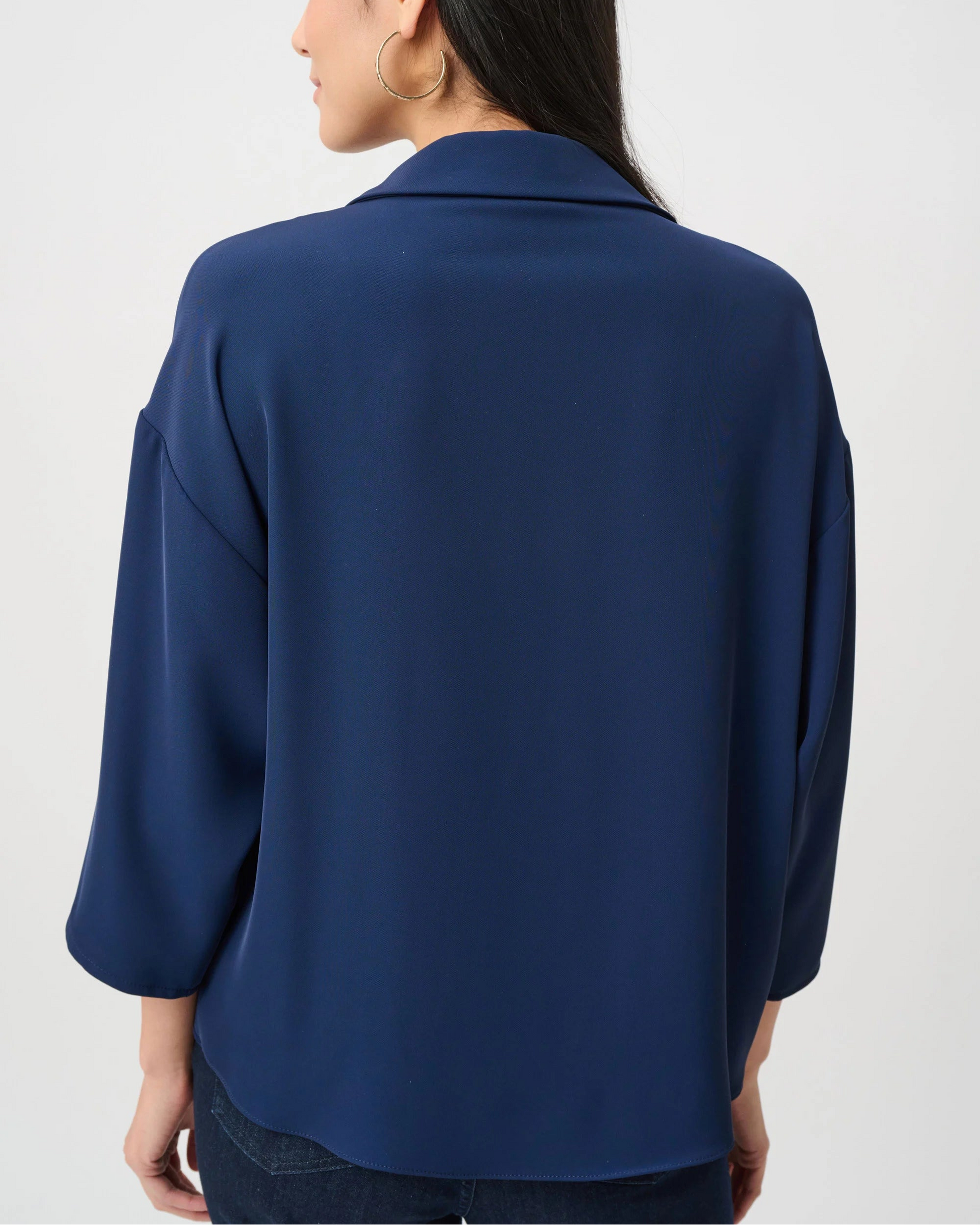 Person wearing a blue blazer from behind on a white background