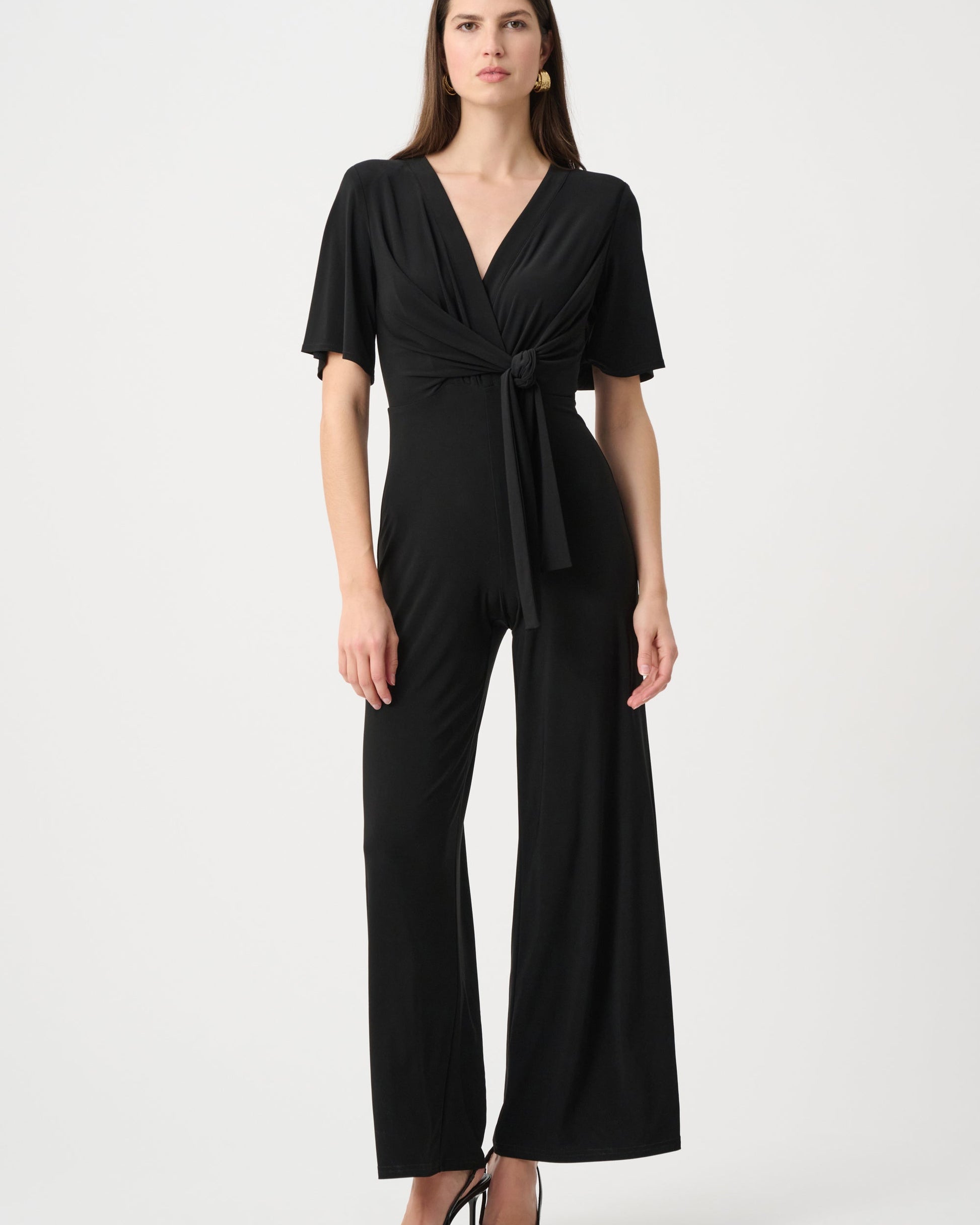 Woman wearing a black jumpsuit on a white background