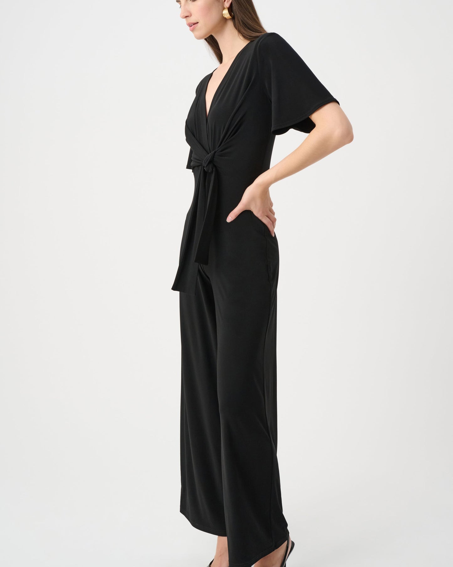 Woman wearing a black jumpsuit on a white background