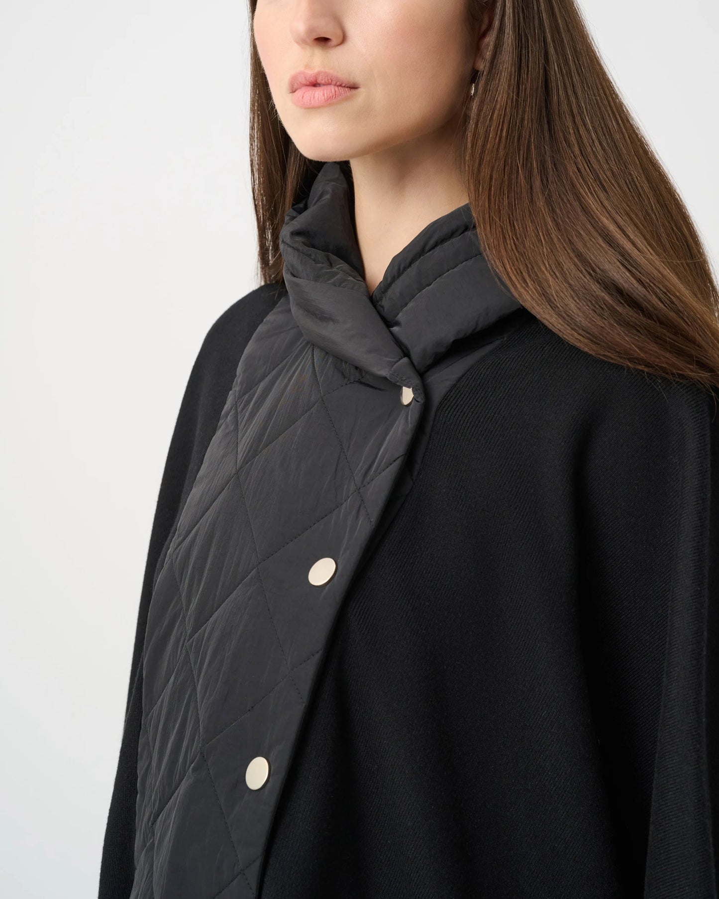 Woman wearing a black coat with a quilted collar against a white background
