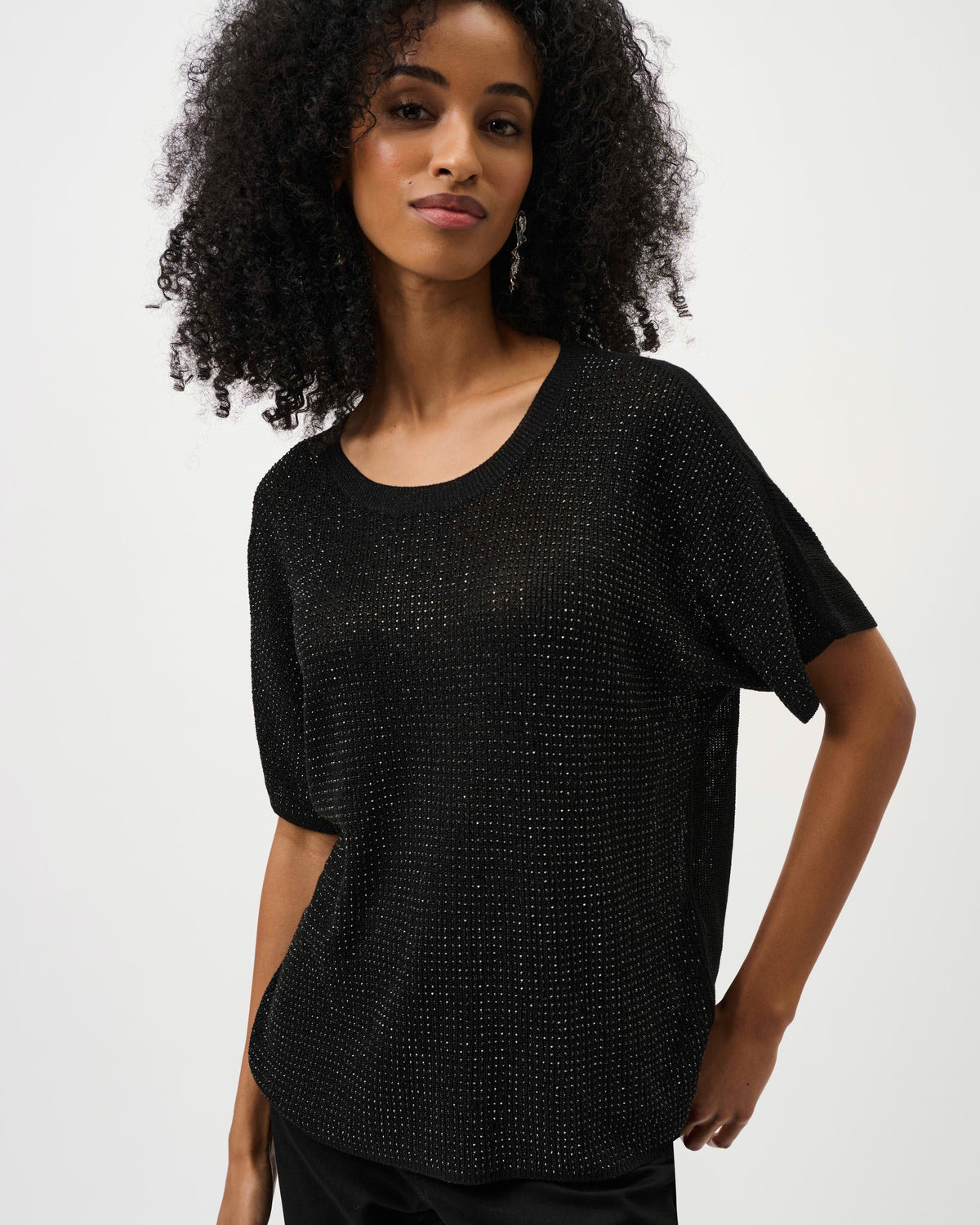 Woman wearing a black textured top against a white background