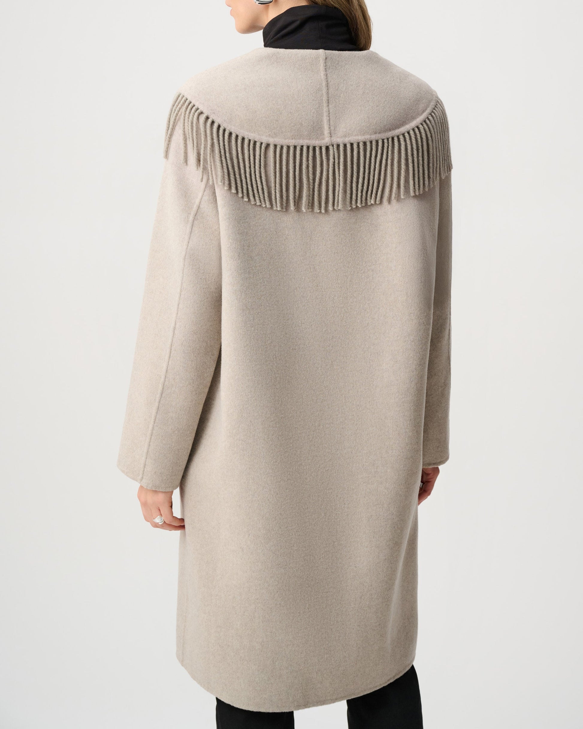 Beige coat with fringe details on a white background