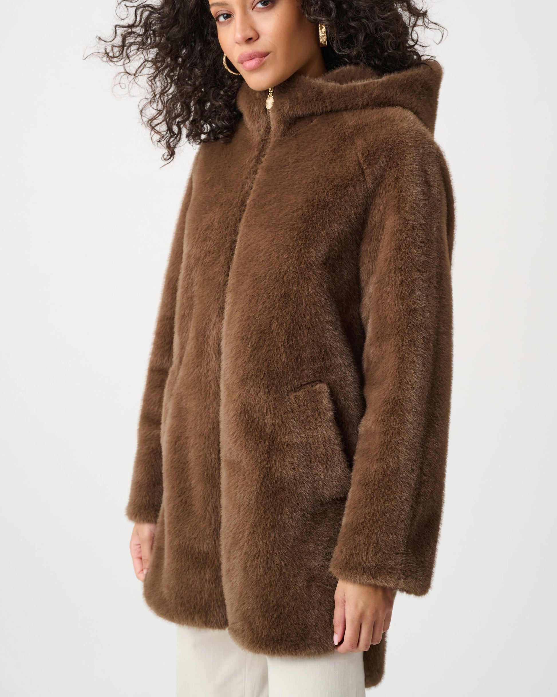 Woman wearing a brown faux fur coat on a white background