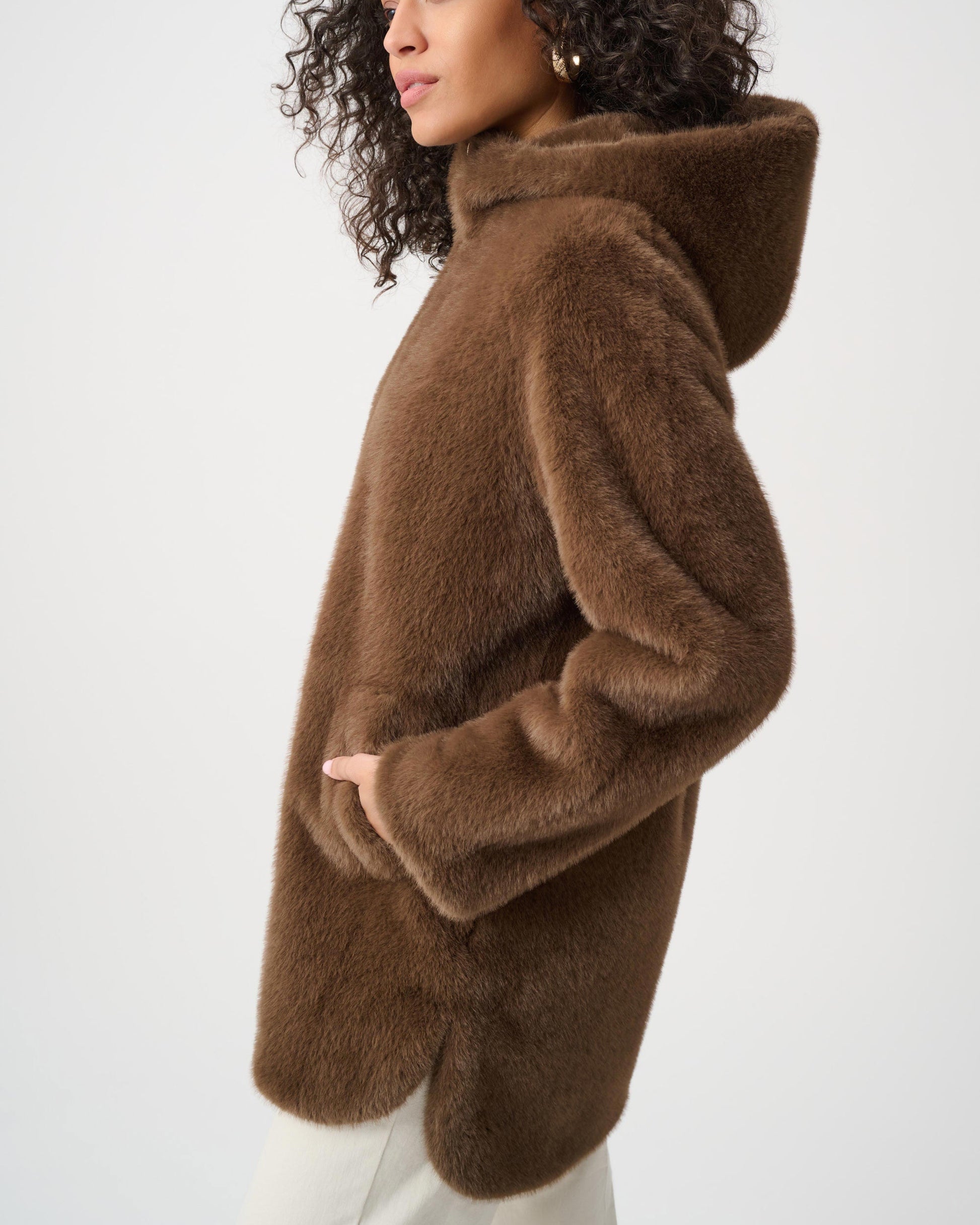 Woman wearing a brown fluffy coat on a white background