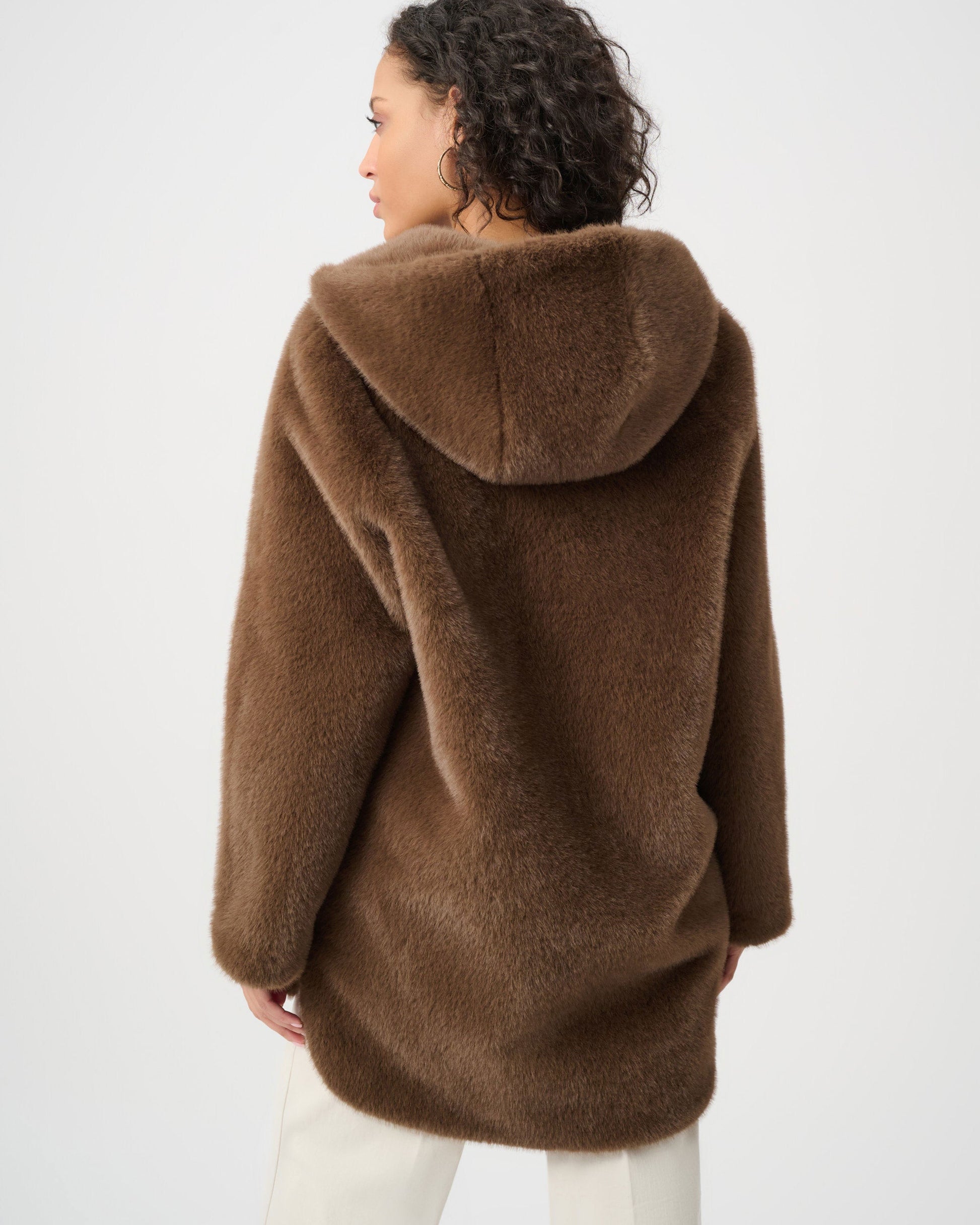 Person wearing a brown hooded coat on a white background