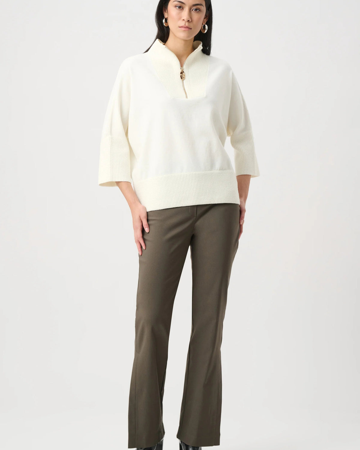 Woman wearing a white blouse and green pants on a white background
