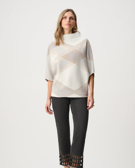 Woman wearing a patterned top and black pants on a white background