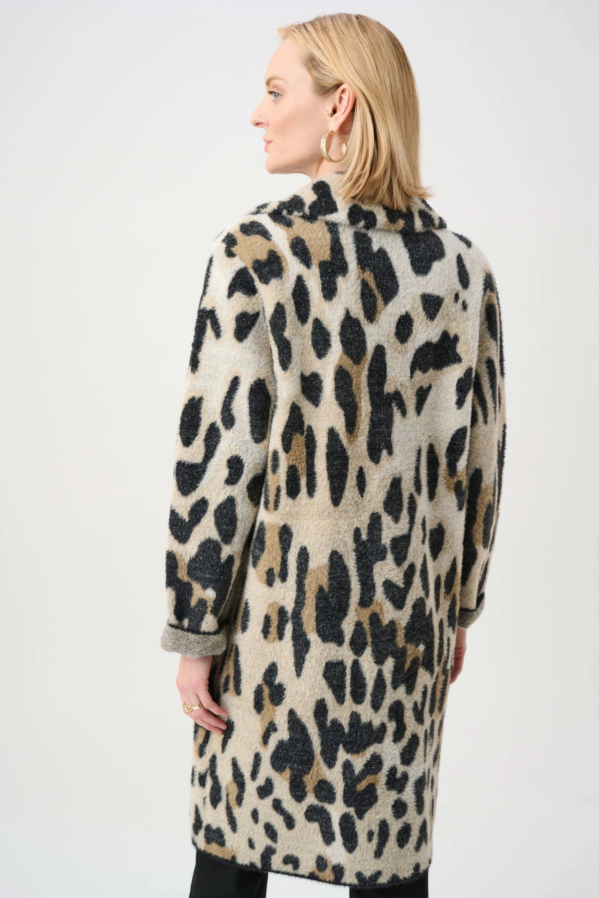 Woman wearing a leopard print coat on a white background