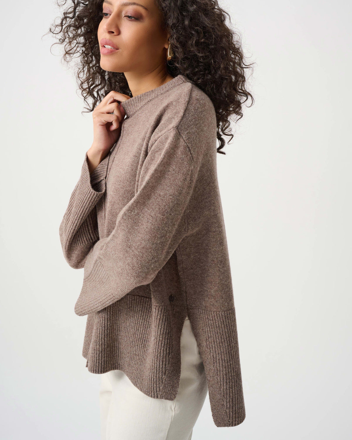 Woman wearing a brown sweater against a white background