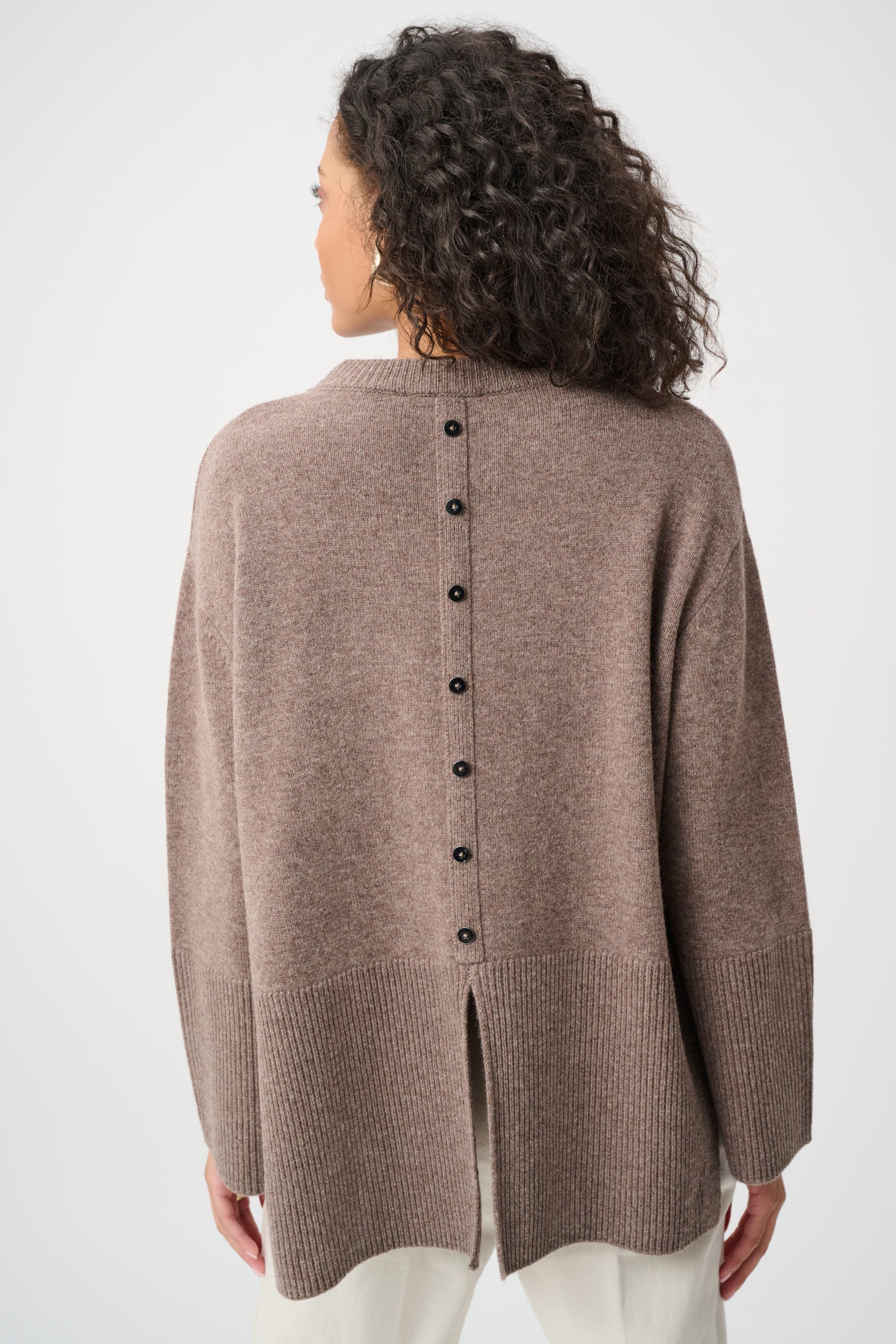 Woman wearing a brown cardigan with buttons on a white background